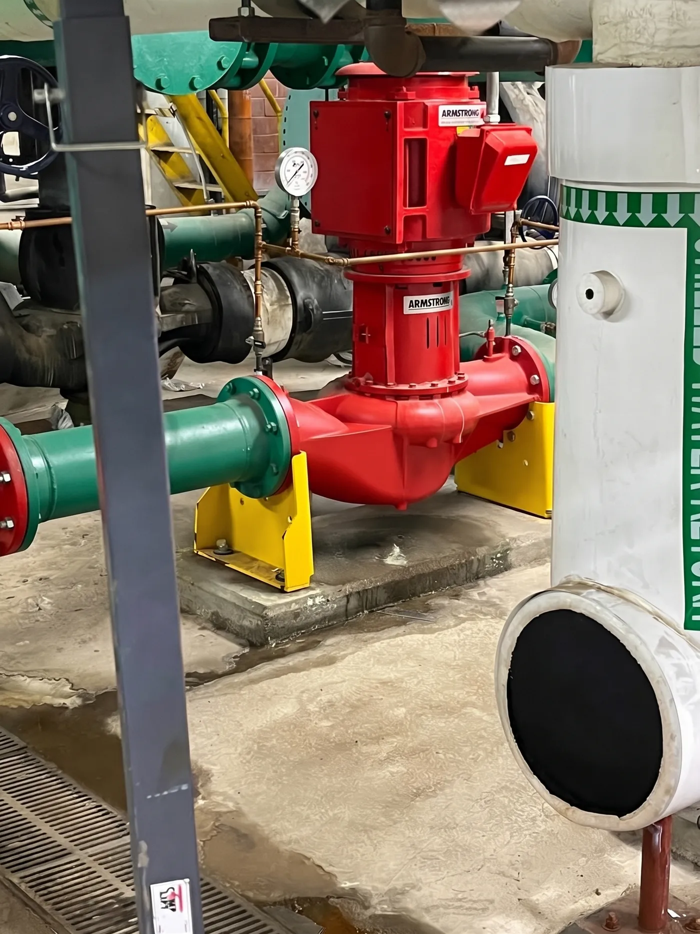 Armstrong vertical in-line pump in a building mechanical room, serviced by Apex