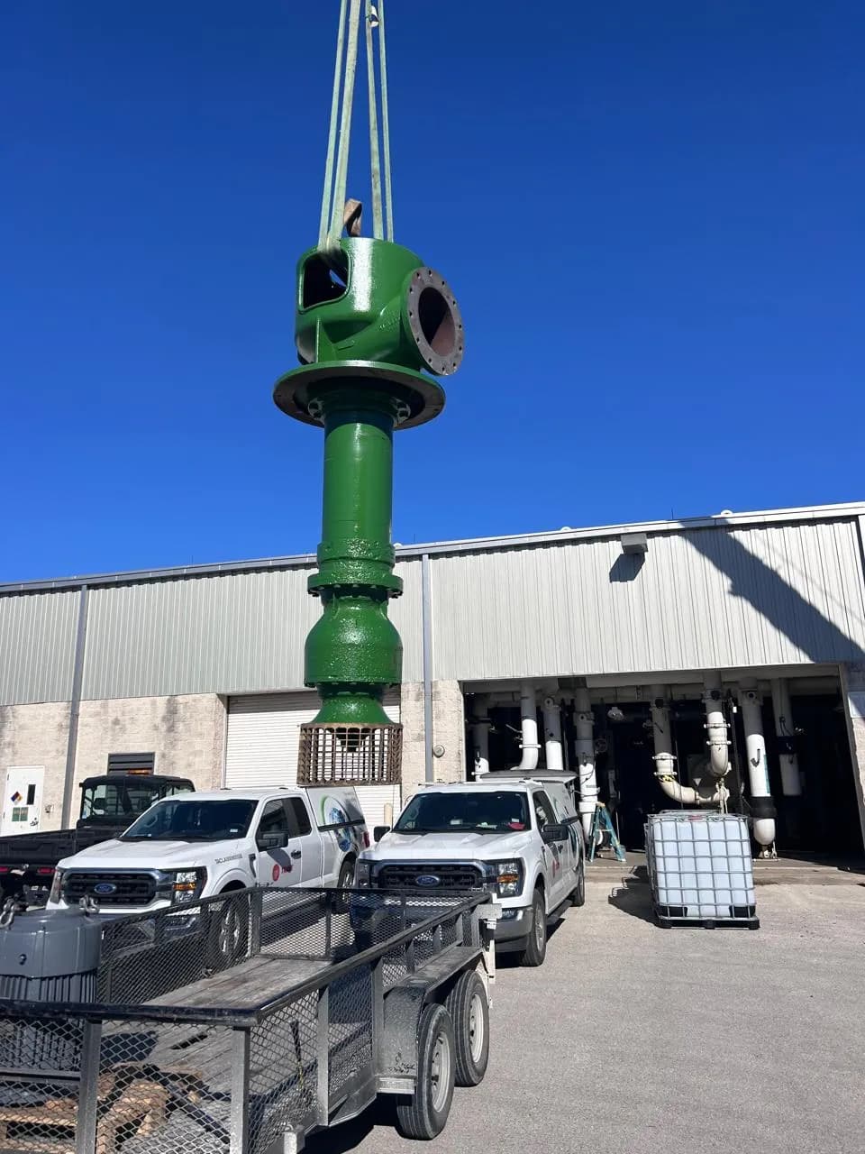 Apex crew rigging a vertical turbine pump outside the shop